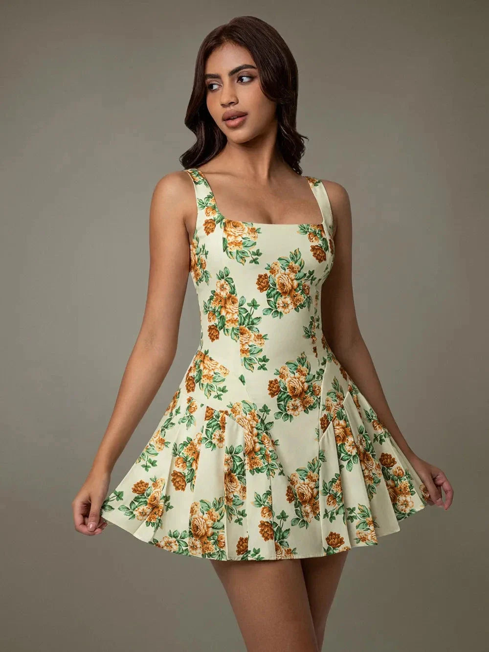 Woman wearing sleeveless floral mini dress with pleated skirt – Blossom Breeze summer outfit  Blossom Breeze Mini Dress