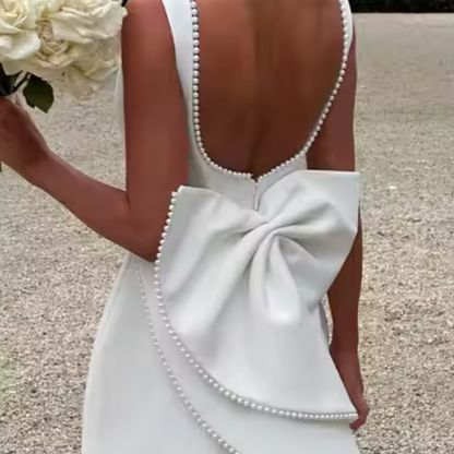 Model wearing Celestine backless mini dress with pearl bow detail – ODI-ONE FASHION
