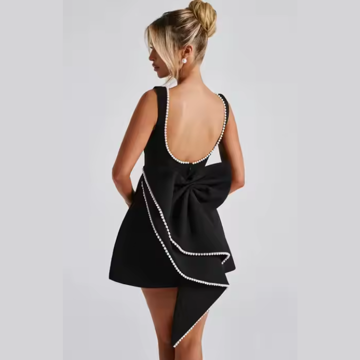 Model wearing Celestine backless mini dress with pearl bow detail – ODI-ONE FASHION
