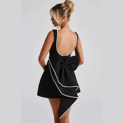 Model wearing Celestine backless mini dress with pearl bow detail – ODI-ONE FASHION
