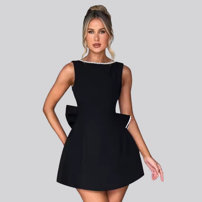Model wearing Celestine backless mini dress with pearl bow detail – ODI-ONE FASHION
