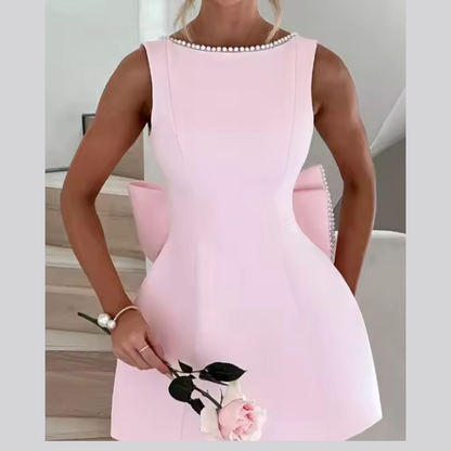 Model wearing Celestine backless mini dress with pearl bow detail – ODI-ONE FASHION
