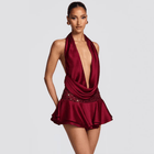 Woman wearing a burgundy dress with a plunging neckline on a gray background