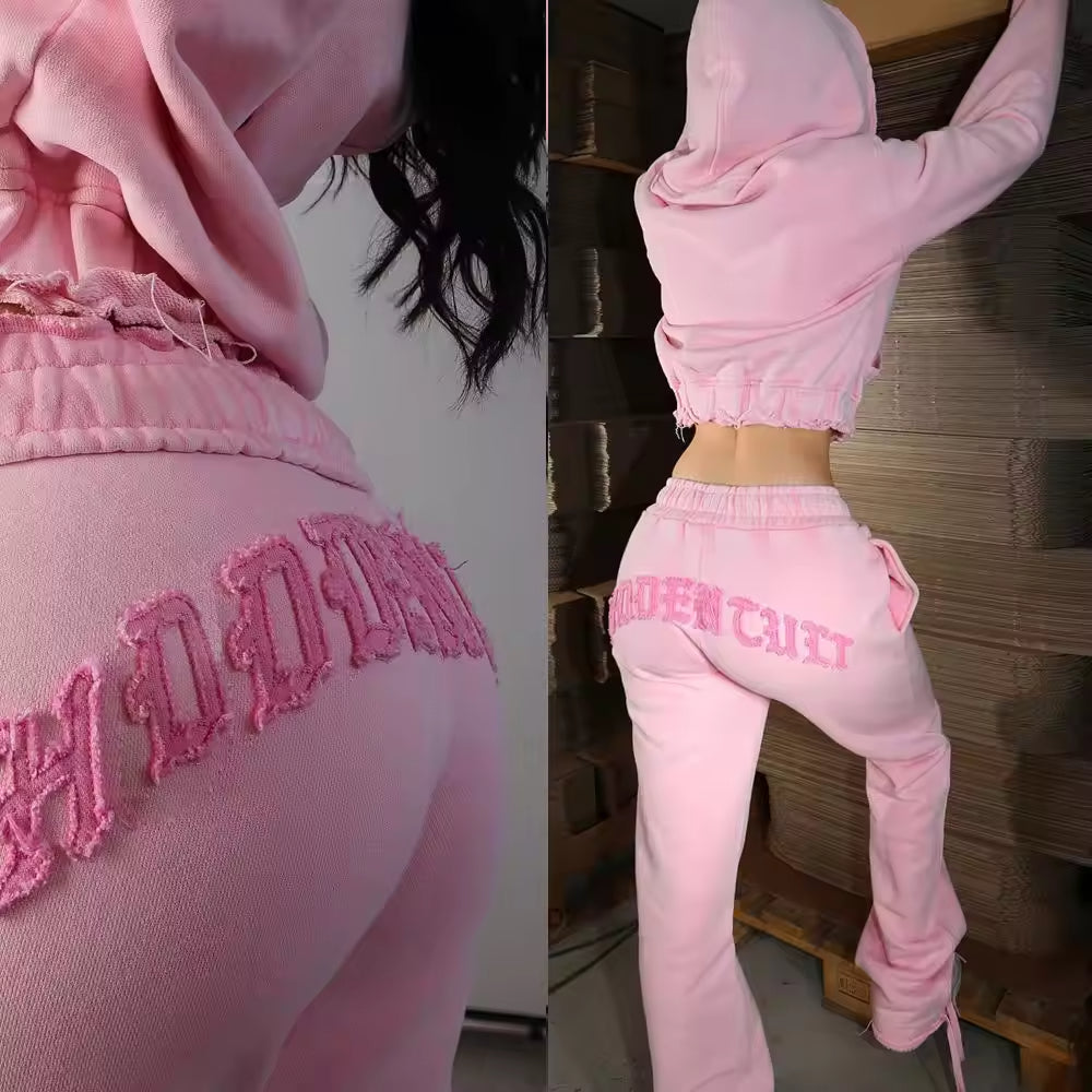 Pink sweatshirt and pants with text on a wooden pallet background