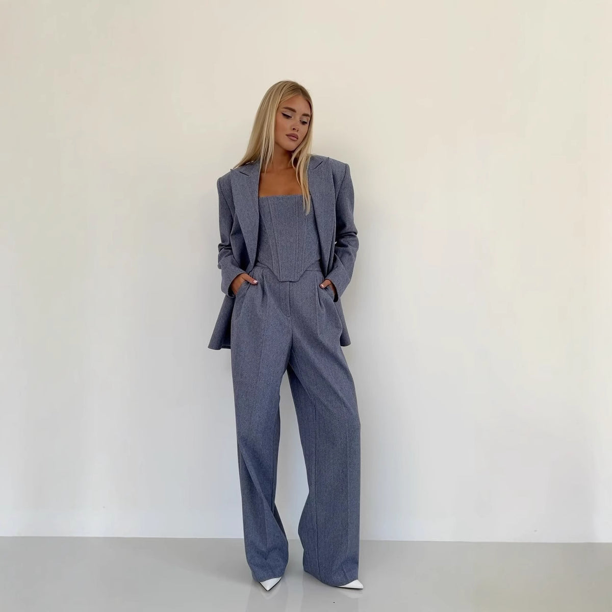 Woman wearing a gray suit against a white background