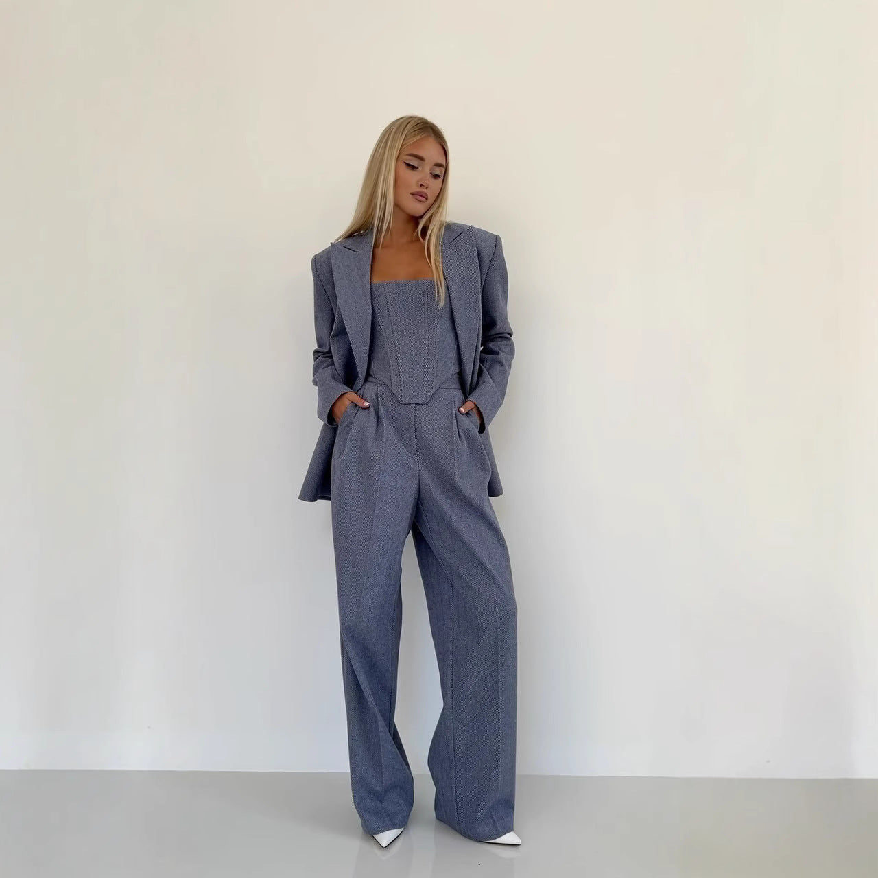 Woman wearing a gray suit against a white background