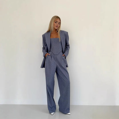 Woman wearing a gray suit against a white background