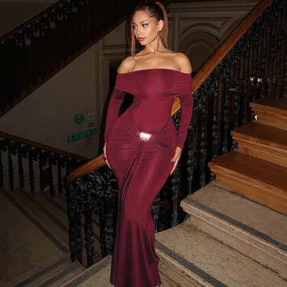 Woman in a burgundy off-shoulder gown standing on a staircase.