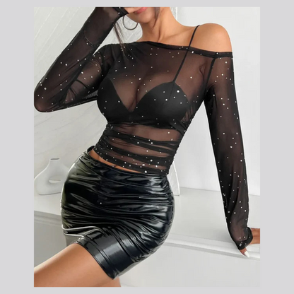 Woman wearing a one-shoulder mesh long sleeve top in a sleek, stylish outfit
