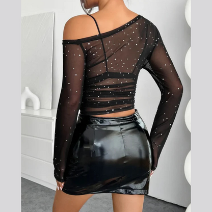 Woman wearing a one-shoulder mesh long sleeve top in a sleek, stylish outfit
