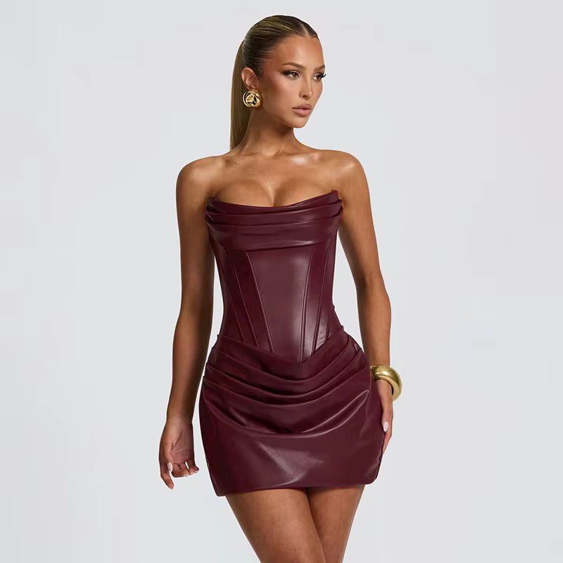 Woman wearing a strapless burgundy dress on a plain background