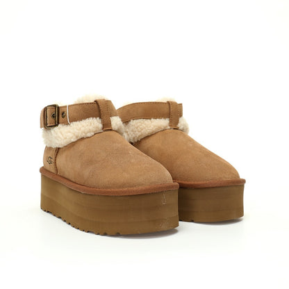 Pair of brown suede platform boots with white fur lining on a white background