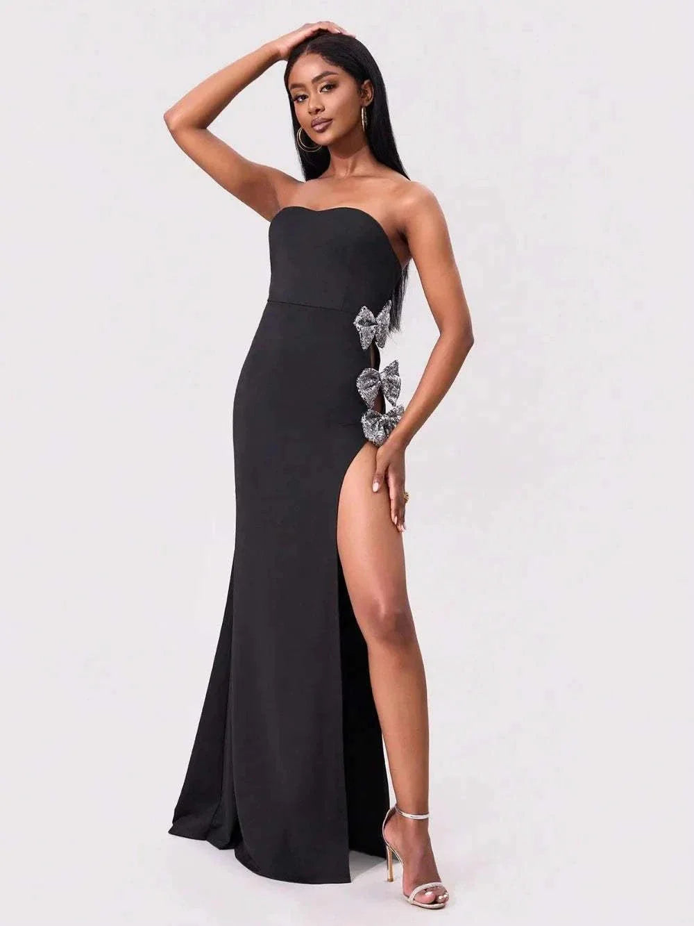 Model wearing strapless tube maxi dress with bow and side slit – elegant black evening look

