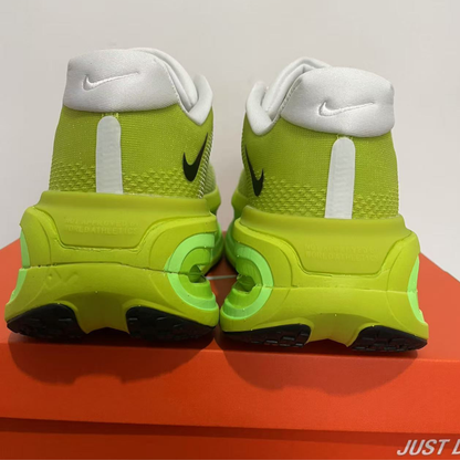 Pair of neon green sneakers with white and black accents on a red and gray background