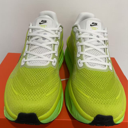 Pair of bright green running shoes with white laces on a red surface.