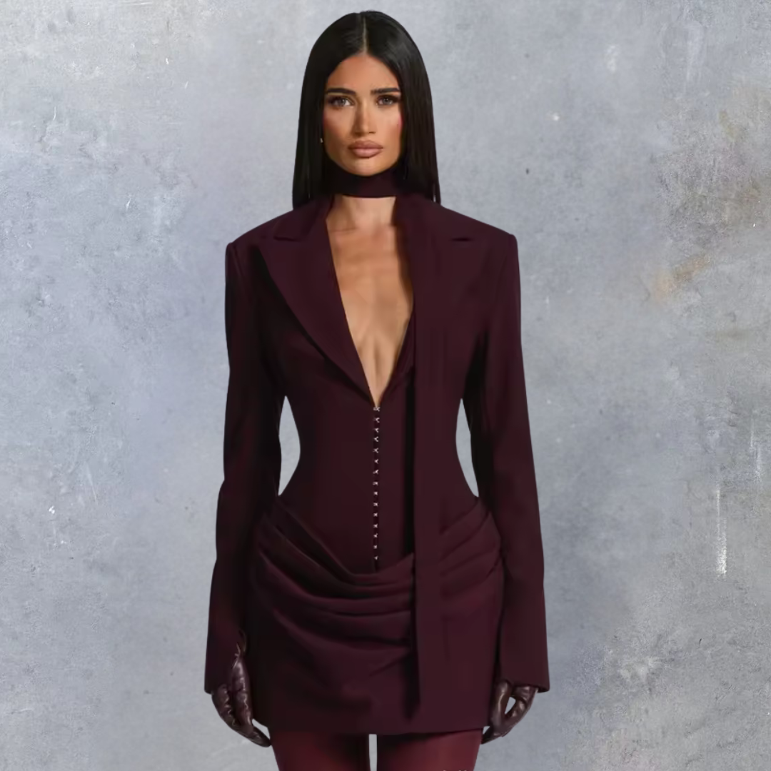 Woman wearing a burgundy suit against a gray background