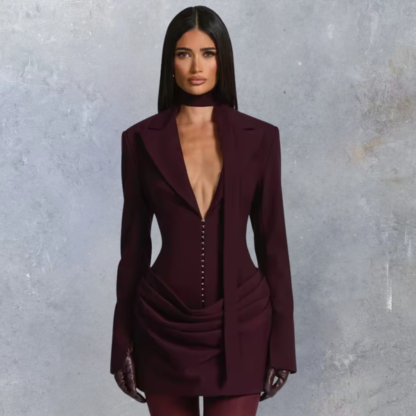 Woman wearing a burgundy suit against a gray background